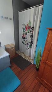 ein Badezimmer mit einer Dusche mit einem Zebra-Duschvorhang in der Unterkunft L'amour Breizh in Plouaret