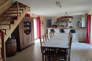 a dining room with a table and chairs and a staircase at L'amour Breizh in Plouaret