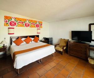een slaapkamer met een bed en een flatscreen-tv bij Parador del Dominico in Oaxaca City