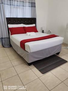 een groot bed met rode kussens op de kamer bij Mosas Home in Serowe