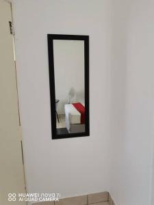 een spiegel aan de muur met een bed in een kamer bij Mosas Home in Serowe