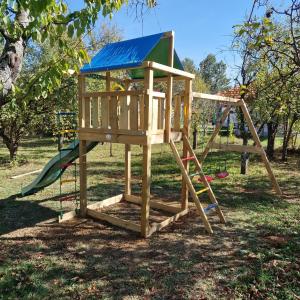 a wooden play structure with a slide and a ladder at Seoska kuca Stojanović in Kladovo