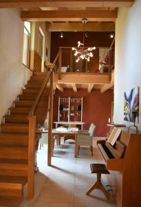 a living room with a staircase and a piano at Chalet Zauberberg in Zwiesel