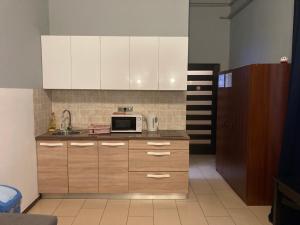 a kitchen with wooden cabinets and a microwave at Boomerang Hostel in Budapest