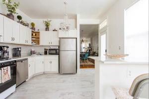 a kitchen with white cabinets and a stainless steel refrigerator at Central Pittsburgh 5-Bed Haven in Pittsburgh
