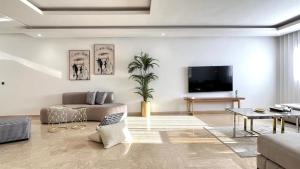 a living room with a couch and a tv at Family 3 Bedrooms- By AppartAli in Casablanca