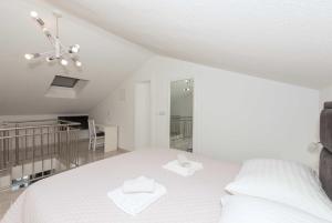 a bedroom with a white bed with two towels on it at Apartments M&A 2 in Makarska