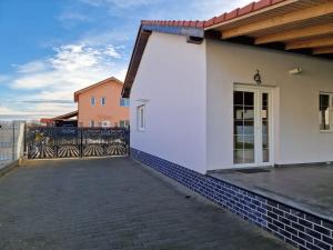 une maison blanche avec une clôture et une terrasse dans l'établissement Home in Residential Neighborhood, à Arad