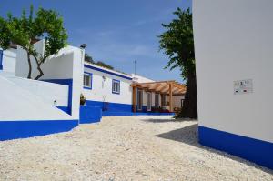 a house with blue and white walls and trees at Casa do Forte Elvas in Elvas