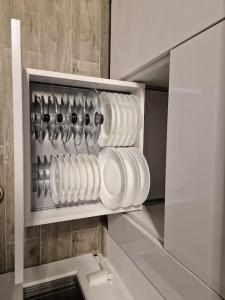 un estante lleno de platos y utensilios blancos en Home in Residential Neighborhood, en Arad