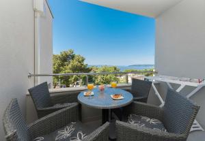 a balcony with a table with two glasses of orange juice at Apartments M&A 2 in Makarska