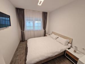 - une chambre avec un lit blanc et une fenêtre dans l'établissement Home in Residential Neighborhood, à Arad