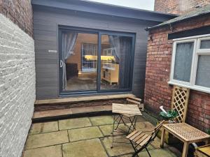 un patio con 2 sillas, una mesa y una ventana en Carlisle City Centre. The Annex. en Carlisle