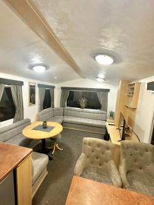 sala de estar con sofá y mesa en Goldflinch - 3 bedroom (8 birth) caravan Sand Le Mere, en Waxholme