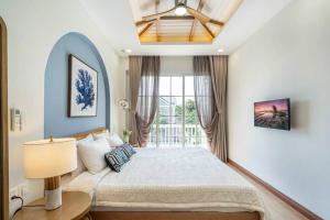 a bedroom with a large bed and a window at Coastal Sunshine Villa NovaWorld Phan Thiết in Bình Tú