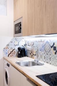 - un comptoir de cuisine avec évier et four micro-ondes dans l'établissement Chic Central Madrid, à Madrid