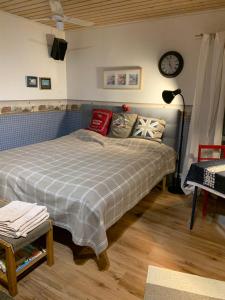 1 dormitorio con 1 cama y reloj en la pared en Erillinen ilmastoitu vierassviitti, Kokkola, en Kokkola