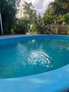 una piscina de agua azul en un patio en Pousada Neide, en São Gabriel
