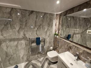a bathroom with a sink and a toilet and a mirror at Carlisle City Centre The Wash House in Carlisle +13 photos