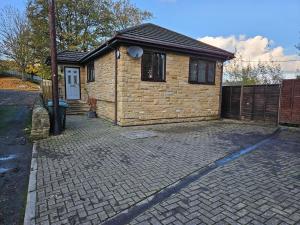 a small brick house with a brick driveway at Lister Park Bradford 2bed Detached Cottage House & Parking & Cinema Screen in Shipley