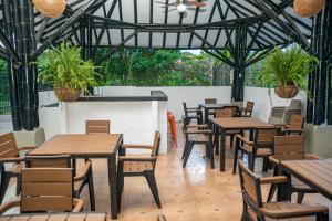 a restaurant with wooden tables and chairs and plants at Eco Hotel La Aurora Cabañas in Calarcá