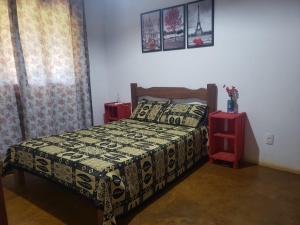a bedroom with a bed and two red side tables at Casa do Rogério in Santana do Riacho