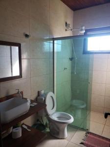 a bathroom with a shower and a toilet and a sink at Casa do Rogério in Santana do Riacho