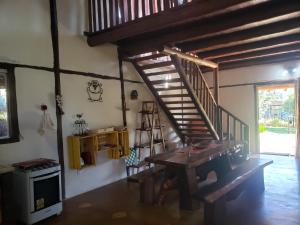 a living room with a wooden staircase and a table at Casa do Rogério in Santana do Riacho