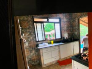 a kitchen with a counter top and a window at Recanto Abadia in Ribeirão
