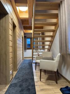 una sala de estar con techos de madera y una escalera. en Drevenica Skye Terchová en Terchová