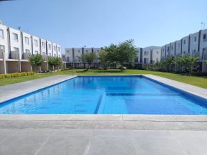 a swimming pool in front of a building at Casa de descanso en residencial in Tlayecac