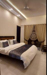 a bedroom with a large bed and curtains at RADIANT GUEST HOuSE 2 in Islamabad