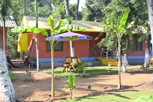 ein Haus mit einem Regenschirm davor in der Unterkunft amee's retreat in Diveagar