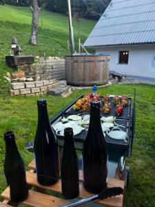 a grill with three bottles on top of it at Jurček Holiday Home in Kotlje