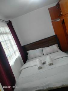 uma cama com duas toalhas em cima em Tranquil 2 homes em Nanyuki