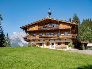een groot houten huis bovenop een heuvel bij Luxusappartement Alpenliebe in Oberndorf in Tirol