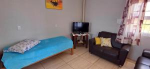 uma pequena sala de estar com um sofá e uma televisão em Ap térreo a 50 metros do mar em Balneário Gaivotas