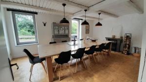 une salle à manger avec une grande table et des chaises en bois dans l'établissement Maison de Rochehaut, à Rochehaut