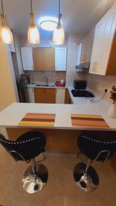 a kitchen with a counter and two bar stools at Enzi heights in Nairobi
