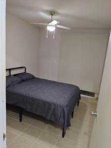 1 dormitorio con 1 cama y ventilador de techo en Casa de descanso en residencial, en Tlayecac