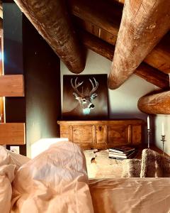 a bedroom with a painting of a deer on the wall at La Stalla in Vicosoprano