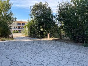 a stone driveway with trees and a building in the background at Il Rifugio in San Giacomo degli Schiavoni