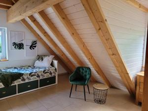 ein Schlafzimmer mit einem Bett und einem Stuhl im Dachgeschoss in der Unterkunft Ferienhaus Naturregion Sieg bis 6 Personen in Windeck