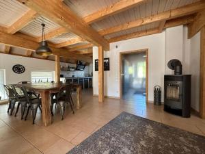 a kitchen and dining room with a table and a fireplace at Ferienhaus Naturregion Sieg bis 6 Personen in Windeck