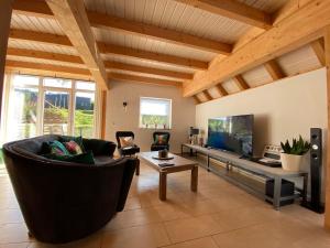 ein Wohnzimmer mit einem Sofa und einem TV in der Unterkunft Ferienhaus Naturregion Sieg bis 6 Personen in Windeck