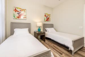 a bedroom with two beds and a table with a lamp at VistaCay Balcony near Pool Convention Ctr iDrive in Orlando