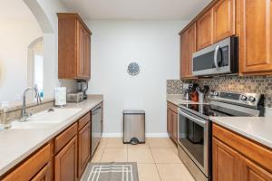 a kitchen with wooden cabinets and a sink at VistaCay Balcony near Pool Convention Ctr iDrive in Orlando