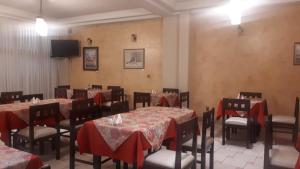 a dining room with tables and chairs and a television at Eurotel Davina in La Paz