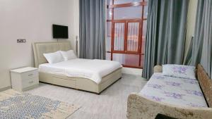 Al Ashkhara Beach House في الشرقية: غرفة نوم بسرير وكرسي ونافذة
