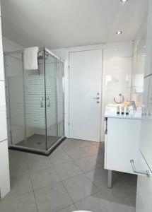 a bathroom with a glass shower and a sink at Sunny 3BR Apartment Golf Residence in Eilat